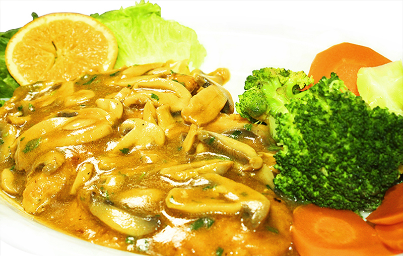 Chicken in mushroom gravy with lettuce, orange slice, broccoli and carrots on white plate; brown, green and orange tones
